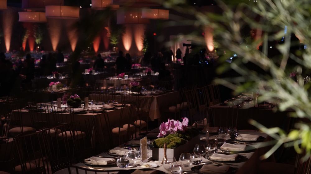 Uplit ballroom gala with orchid and moss centerpieces